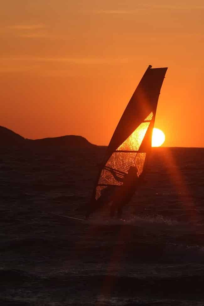 Foto eines Windsurfbretts und eines herrlichen Sonnenuntergangs am Strand von Almanarre, nur wenige Meter von den Unterkünften "Guyanne" entfernt.